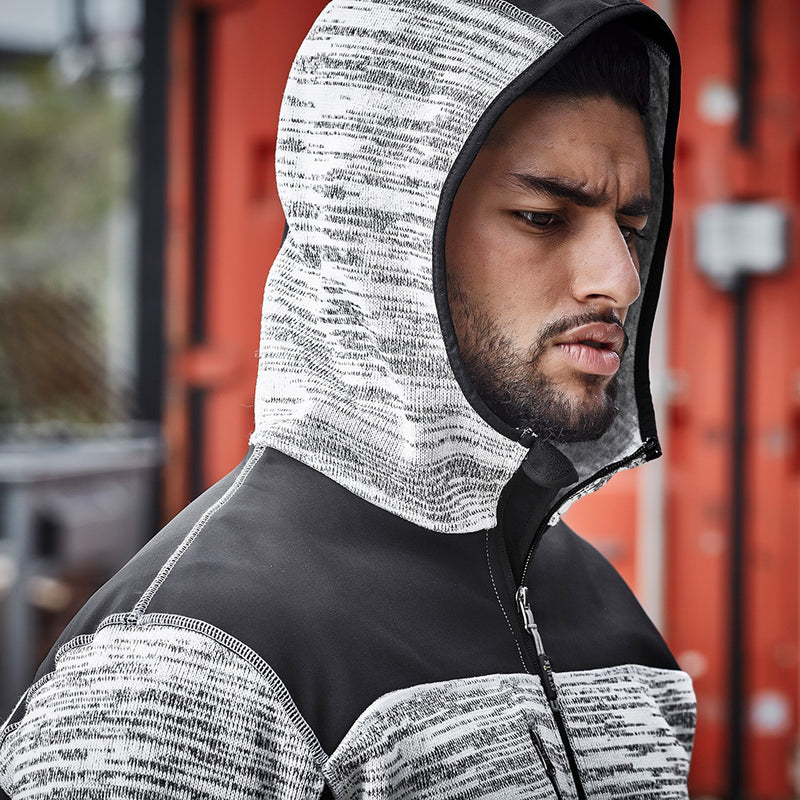 Load image into Gallery viewer, Syzmik Streetworx Knit Hoodie worn by a man, featuring reinforced soft shell panels, zip pockets, and thumb holes for built-in gloves. Ideal for safety and work environments, emphasizing functionality and durability.