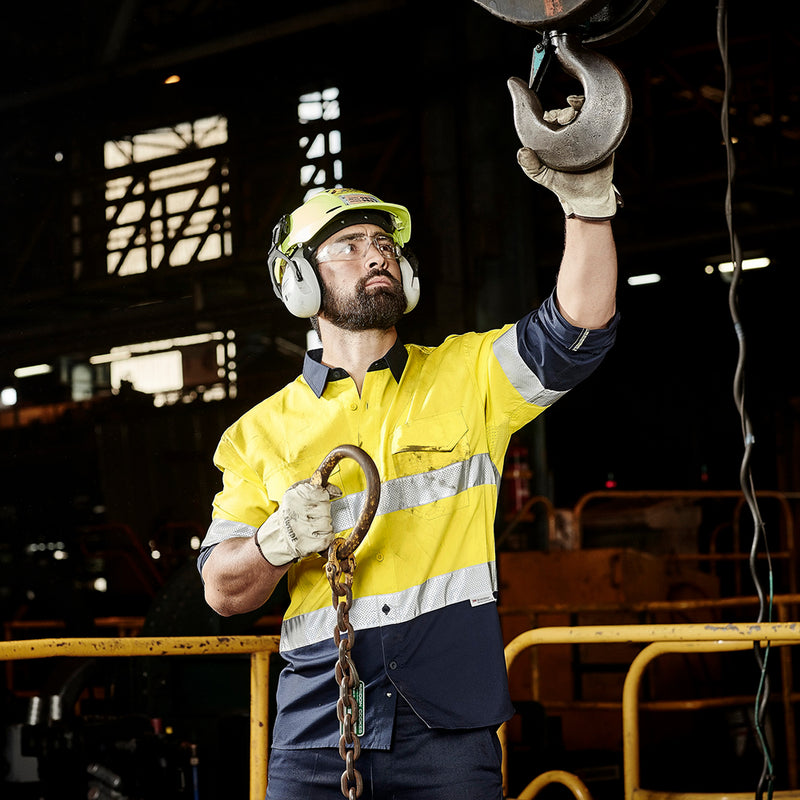 Load image into Gallery viewer, Syzmik Hi Vis Rugged Cooling Taped Spliced Shirt worn by a man with safety gear and gloves, demonstrating its functionality with reinforced stress points and breathable mesh venting.