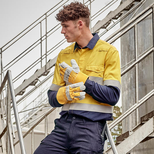 Syzmik FR Taped Lightweight Ripstop Long Sleeve Shirt on a man with curly hair, showcasing the durable ripstop fabric and protective features like gusset sleeve closure and concealed FR placket, highlighting its workplace safety functionality.