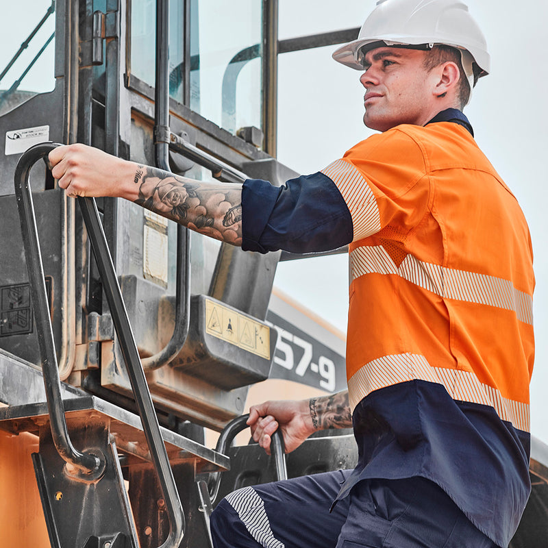 Load image into Gallery viewer, Syzmik Hi Vis Rugged Cooling Ripstop Work Shirt on a man climbing a truck; features segmented tape, mesh venting, and mechanical stretch for enhanced comfort and movement. Ideal for blue-collar workers.