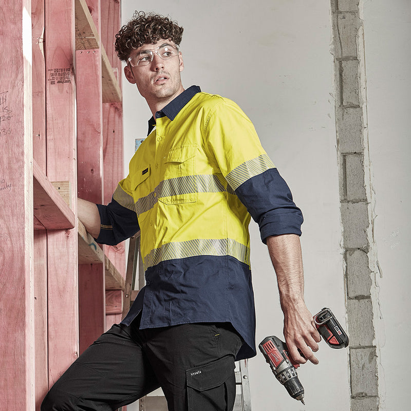 Load image into Gallery viewer, Syzmik Hi Vis Rugged Cooling Ripstop Work Shirt worn by a man in safety gear, holding a drill, highlighting its breathable mesh venting and reinforced stress points for enhanced safety and comfort.