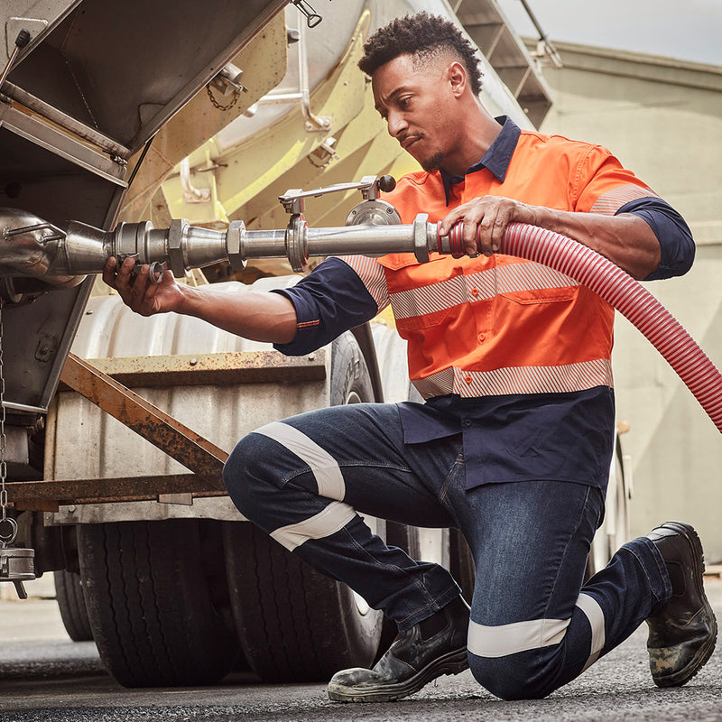 Load image into Gallery viewer, Syzmik Hi Vis Rugged Cooling Ripstop Work Shirt worn by a man kneeling by a truck, highlighting mesh venting and segmented tape for enhanced breathability and comfort in active work environments.