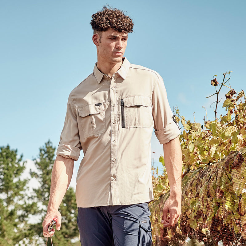 Load image into Gallery viewer, Syzmik Outdoor Long Sleeve Work Shirt, worn by a man outdoors, features roll-up tab sleeves and chest pockets, ideal for workplace safety and comfort, showcasing its lightweight, breathable design.