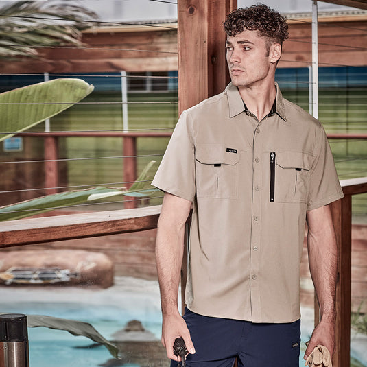 Syzmik Outdoor Ripstop Work Shirt: Man in short-sleeved, lightweight, crinkle-resistant shirt with chest and mobile phone pockets, showcasing breathable mesh underarms and back vents, ideal for workwear.
