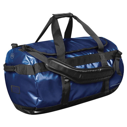 Load image into Gallery viewer, Stormtech Waterproof Gear Bag - Medium, a blue duffel with black straps, features durable waterproof fabric, adjustable padded shoulder straps, and an ID pocket, ideal for safety and work accessories.