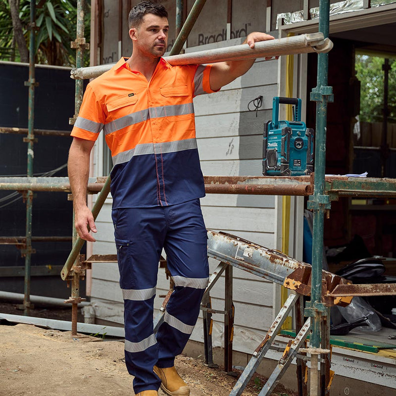 Load image into Gallery viewer, Man in high-visibility Bisley X Airflow Taped Stretch Ripstop Lightweight Cargo Pants stands on scaffolding, showcasing the pants' reflective tape, cargo pockets, and reinforced belt loops at a construction site.
