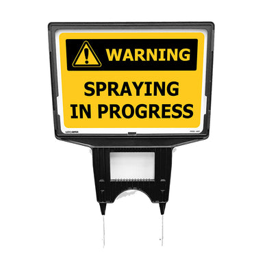 Warning: Spraying In Progress Sign (Holder Included) features a bright yellow design with bold black text and a hazard symbol, mounted on metal spikes for easy ground insertion, ideal for safety alerts.
