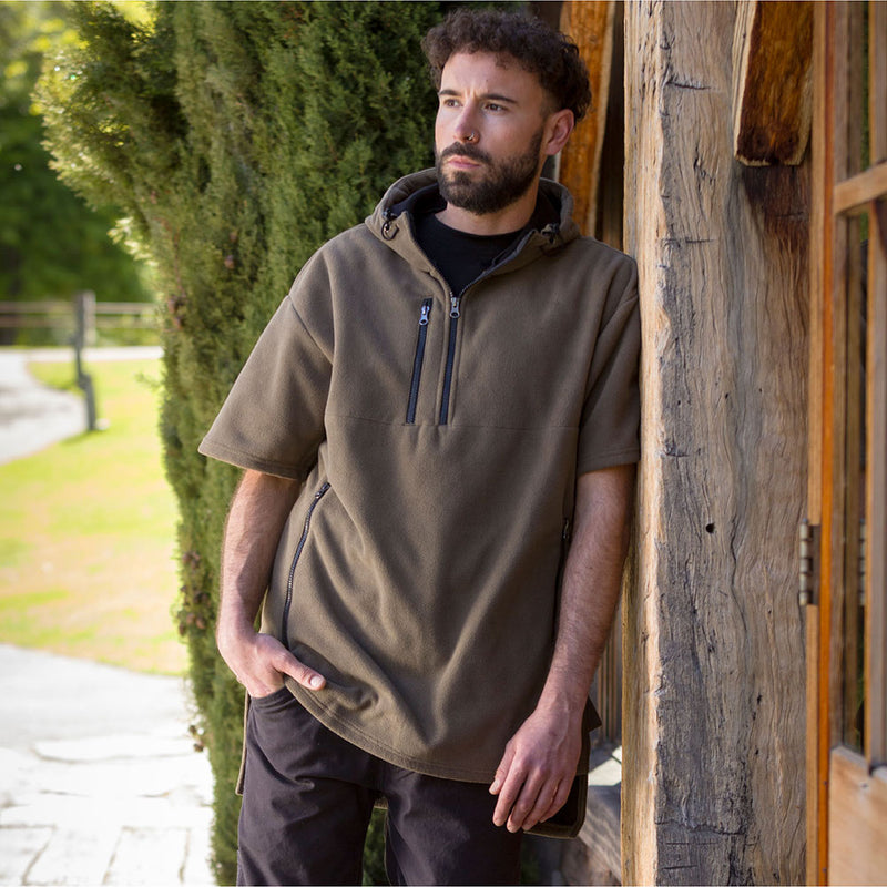 Load image into Gallery viewer, Cloke Hauroko Windproof Short Sleeve Fleece on a man outdoors, showcasing its adjustable hood, super-sized pouch pocket, and breathable design, ideal for active safety and protection in windy conditions.
