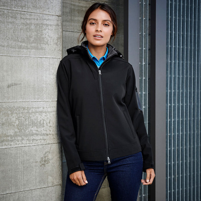 Close-up of a woman wearing the Biz Ladies Summit Jacket, showcasing its detachable hood and adjustable cuffs, emphasizing water repellent, breathable, and windproof features designed for active safety.