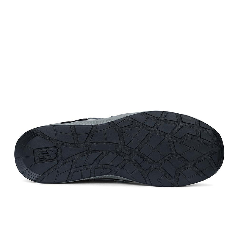 Load image into Gallery viewer, Underside view of the New Balance Elite Lite Safety Shoe, showcasing its treaded rubber sole with a visible NB logo, highlighting slip resistance and durability for light-duty workplace conditions.
