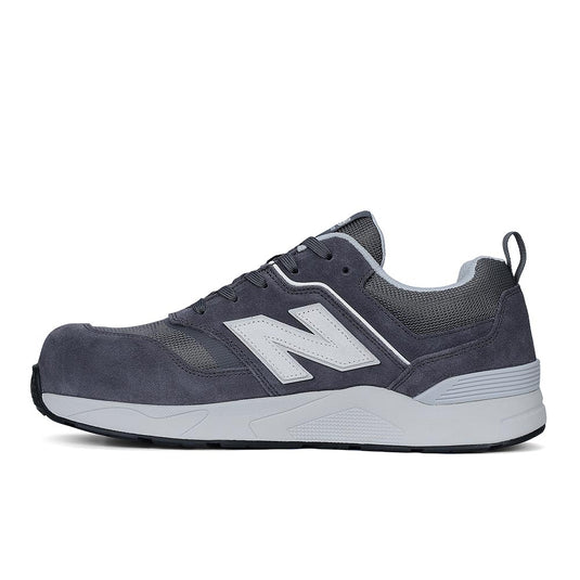 New Balance Elite Lite Safety Shoe, Grey/White, features a dark gray suede/mesh upper with a lighter gray midsole, showcasing the “N” logo, designed for comfort, safety, and modern workplace style.