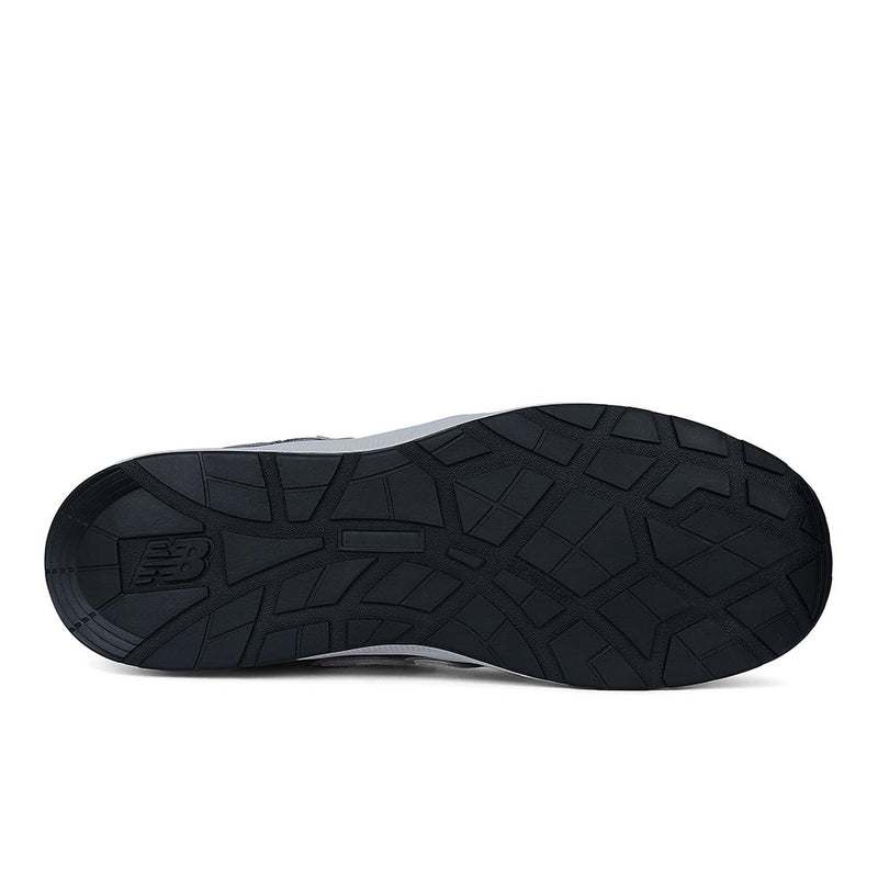 Load image into Gallery viewer, Underside view of the New Balance Elite Lite Womens Safety Shoe, featuring a black tread-patterned outsole with the NB logo, designed for slip resistance and safety in light industrial settings.
