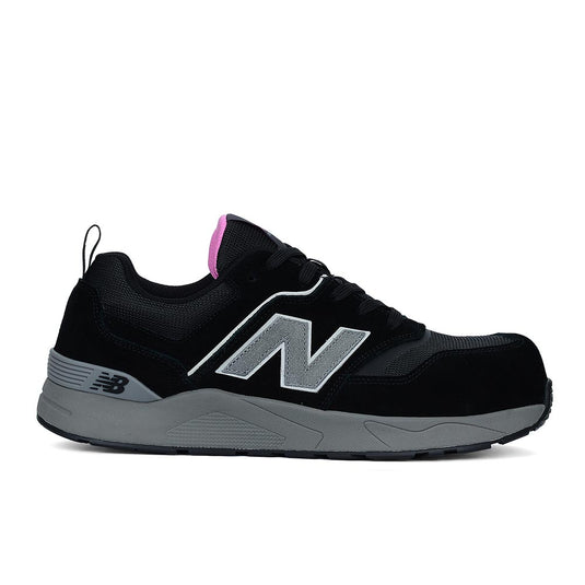 New Balance Elite Lite Womens Safety Shoe, Black/Rose, featuring a black design with grey midsoles and a composite safety toe, highlighted by a grey N logo and pink accent on the tongue.