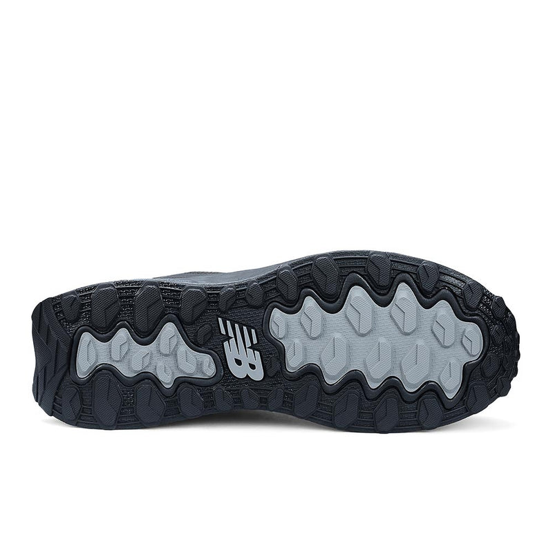 Load image into Gallery viewer, Underside of New Balance Fresh Foam Cremorne Women&#39;s Safety Shoe, Black/Grey, showcasing lugged tread pattern in dark and light gray rubber with NB logo, highlighting slip resistance and durability for workplace safety.
