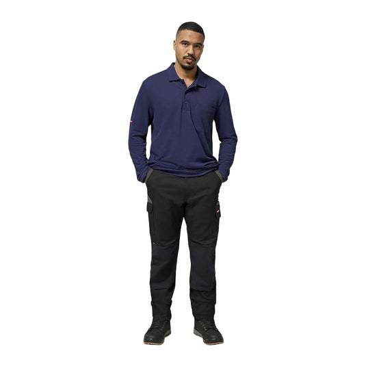 A male model showcases Hard Yakka Legends Slim Fit Stretch Work Pants with reinforced knee panels and utility pockets, styled with black work boots, embodying Active Safety's blend of style and workplace functionality.