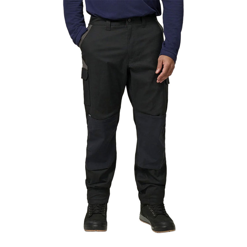 Load image into Gallery viewer, Hard Yakka Legends Slim Fit Stretch Work Pants feature reinforced knee panels, side cargo pockets, and a slim, tapered fit, complemented by durable black work boots, ideal for modern workplace utility.
