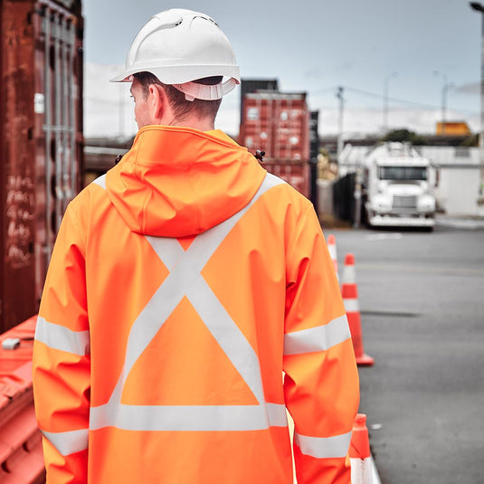 Syzmik Hi Vis TTMC-W23 X Back PU Rain Jacket designed for robust rain protection, featuring waterproof zips, an adjustable hood for hard hats, Bio Motion tape for visibility, and reinforced stress points.